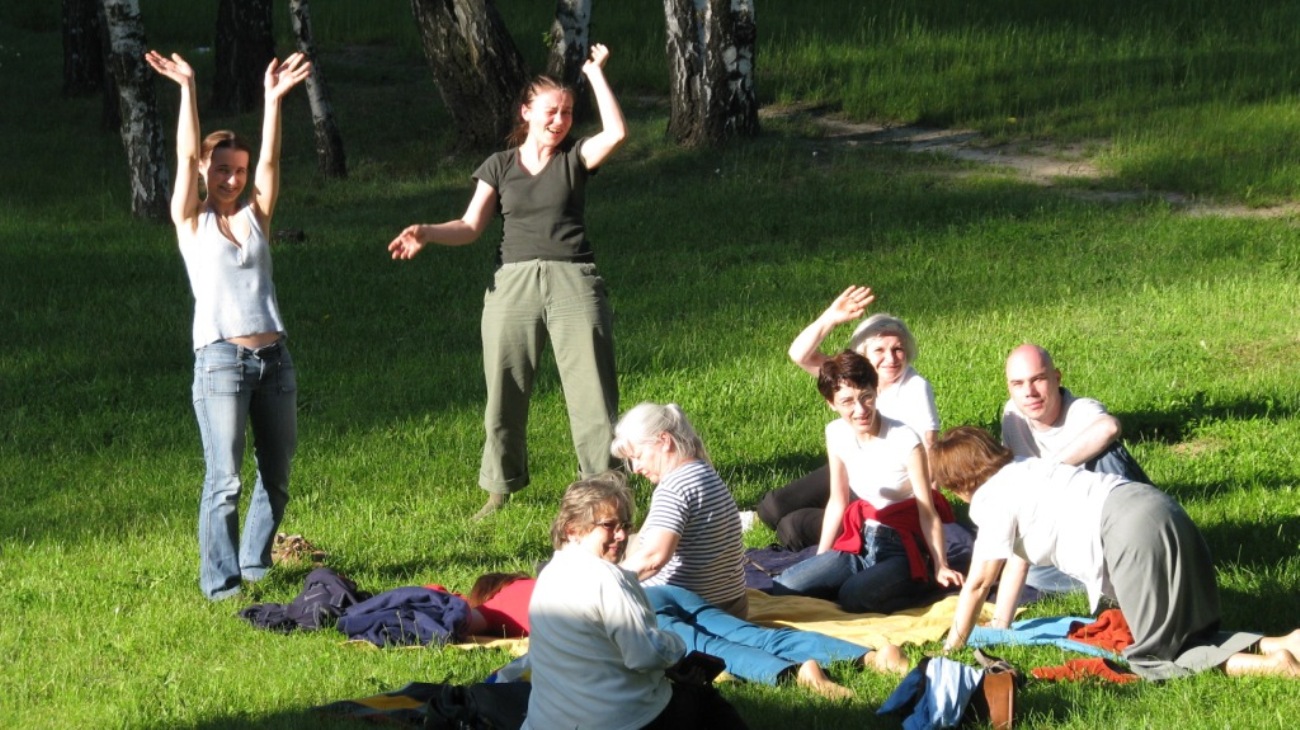 Veselí ľudia odpočívajúci na lúke po príjemnej prechádzke